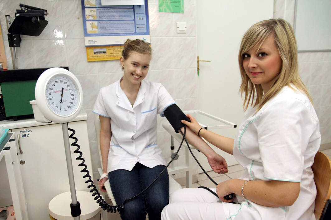 2 studentki pielęgniarstwa w trakcie zajęć praktycznych mierzą ciśnienie